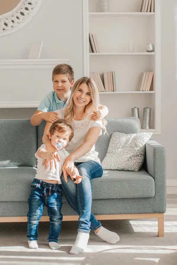 Leena sitting on the couch with her two young sons, showing the balance between motherhood and blogging.